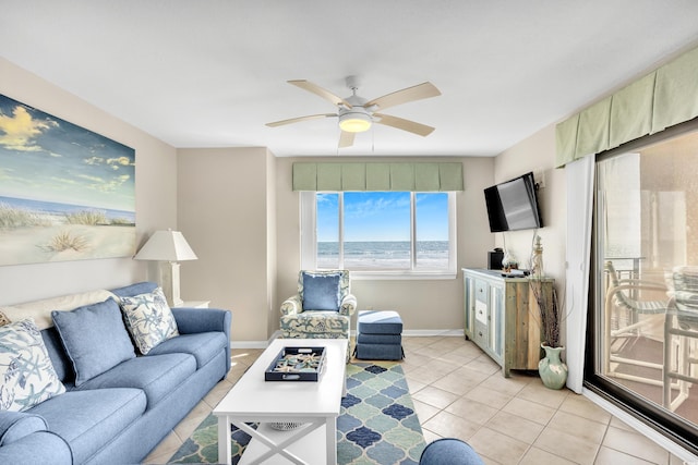 living room with light tile patterned floors, baseboards, and a ceiling fan