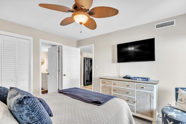 bedroom with visible vents, a ceiling fan, black fridge with ice dispenser, ensuite bath, and a closet