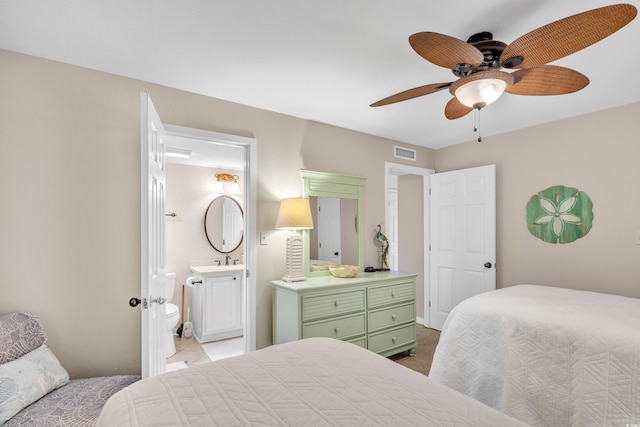 bedroom featuring visible vents, a ceiling fan, a sink, ensuite bath, and carpet floors