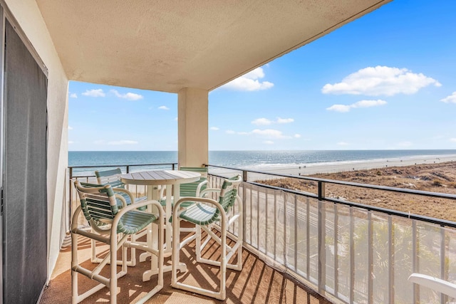 balcony with a water view and a beach view