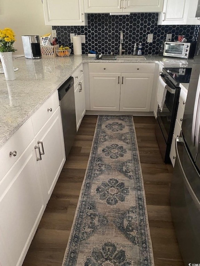 kitchen with dark wood-style flooring, white cabinets, appliances with stainless steel finishes, and a sink