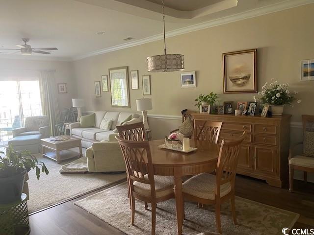 dining space with ceiling fan, wood finished floors, and ornamental molding