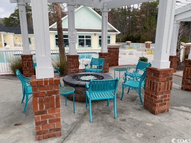 view of patio featuring a fire pit and fence