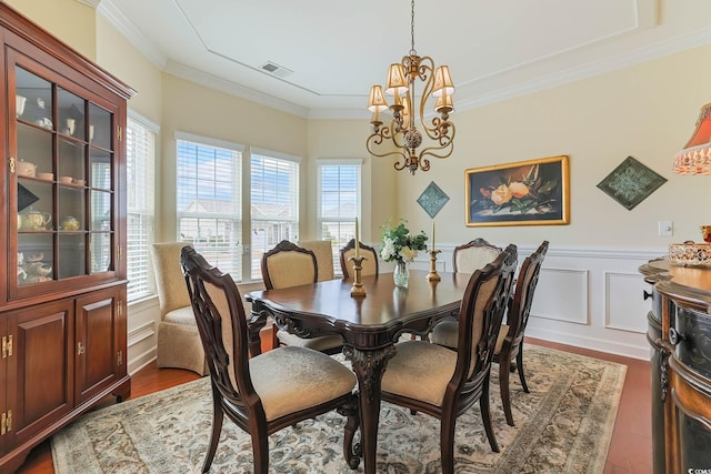 dining space featuring visible vents, wainscoting, crown molding, a chandelier, and dark wood-style flooring