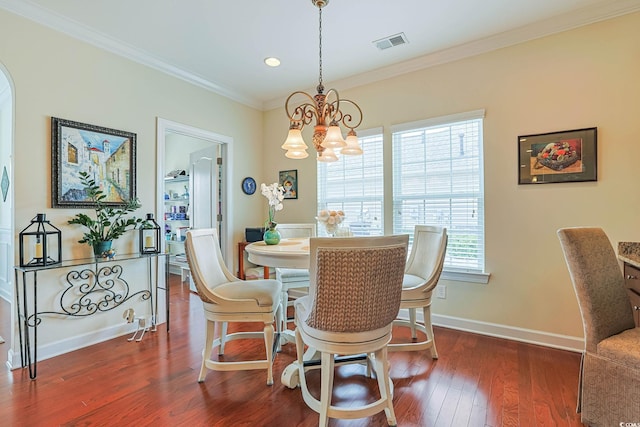 dining room featuring visible vents, an inviting chandelier, crown molding, and dark wood-type flooring