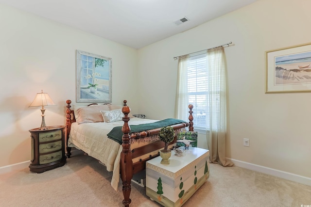 bedroom with visible vents, light carpet, and baseboards