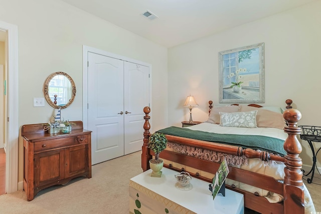 bedroom with light colored carpet, visible vents, and a closet