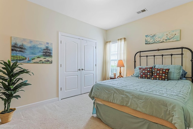 carpeted bedroom featuring baseboards, visible vents, and a closet