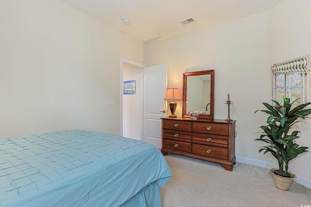 bedroom with light carpet, visible vents, and baseboards