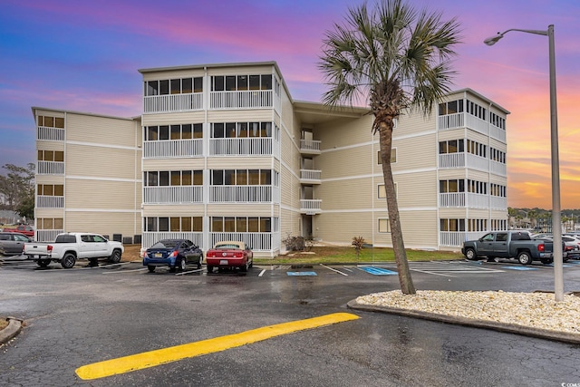 property at dusk with uncovered parking