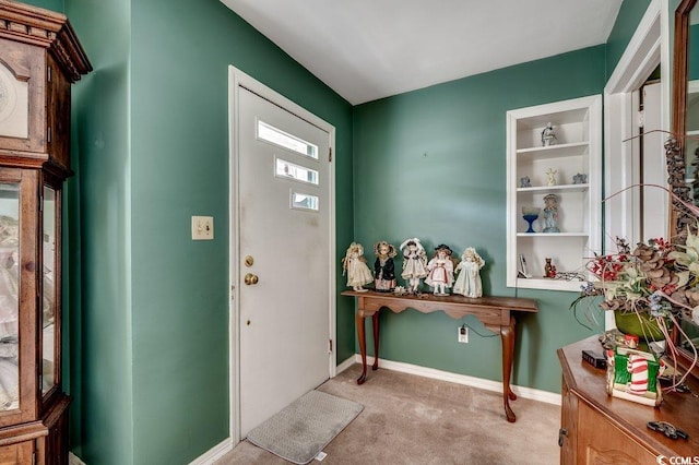 foyer featuring light carpet and baseboards