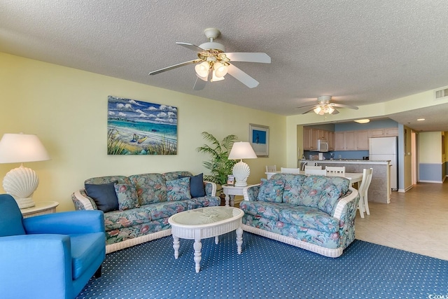 living room featuring light carpet, a ceiling fan, visible vents, and a textured ceiling