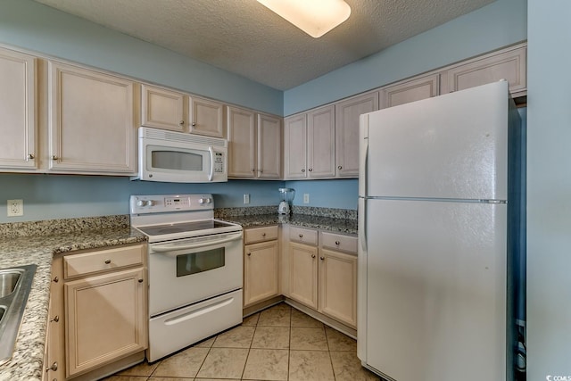 kitchen with light tile patterned floors, cream cabinets, white appliances, a textured ceiling, and a sink