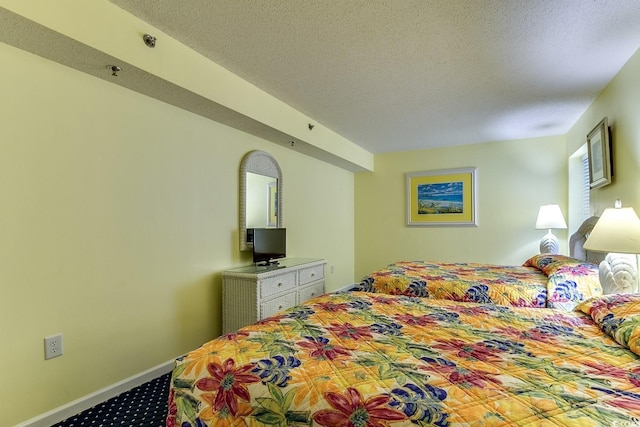 carpeted bedroom with a textured ceiling and baseboards