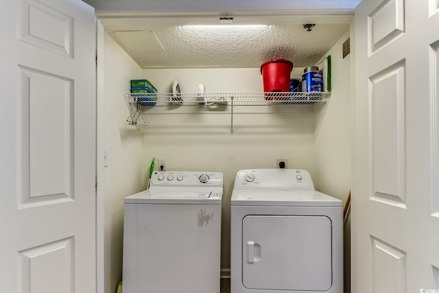 clothes washing area featuring laundry area, independent washer and dryer, and a textured ceiling