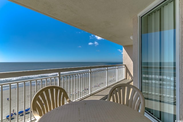 balcony featuring a water view and a beach view