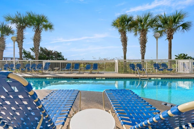 pool with a patio and fence