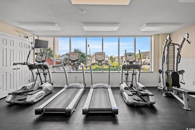 gym with baseboards and a textured ceiling