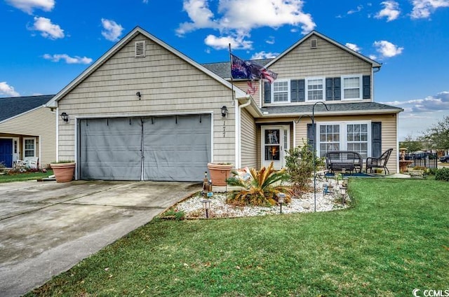 traditional-style house featuring a garage, driveway, and a front yard