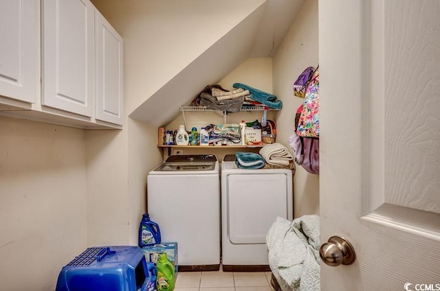 clothes washing area featuring light tile patterned floors, cabinet space, and washing machine and clothes dryer