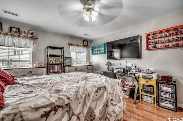 bedroom with visible vents, ceiling fan, and wood finished floors