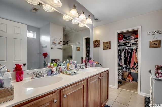 bathroom featuring a sink, a spacious closet, double vanity, and tile patterned flooring