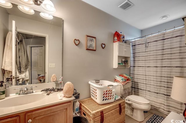 bathroom with visible vents, toilet, a shower with shower curtain, tile patterned floors, and vanity