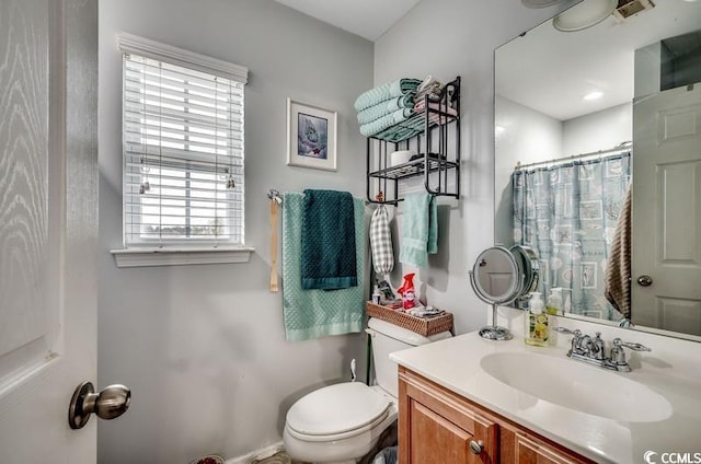 bathroom featuring vanity, a shower with shower curtain, toilet, and visible vents