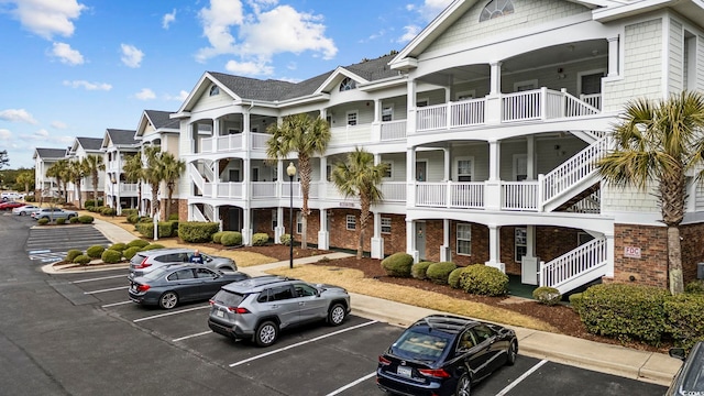 view of building exterior with uncovered parking and a residential view