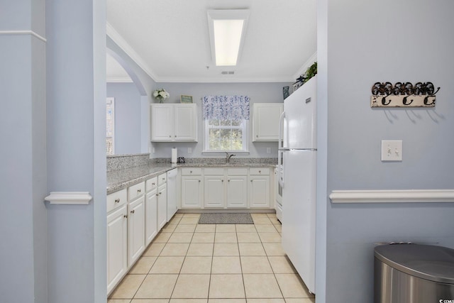 kitchen with ornamental molding, light tile patterned floors, white cabinets, white appliances, and a sink