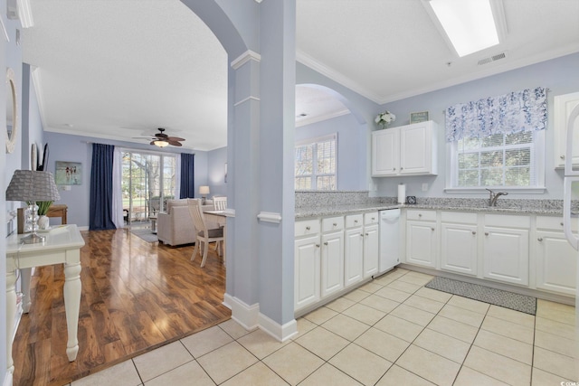 kitchen featuring visible vents, ornamental molding, open floor plan, light tile patterned flooring, and light stone countertops