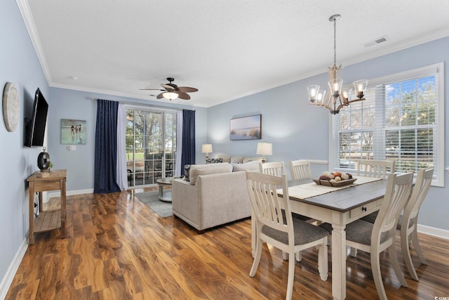 dining room featuring visible vents, ornamental molding, baseboards, and wood finished floors