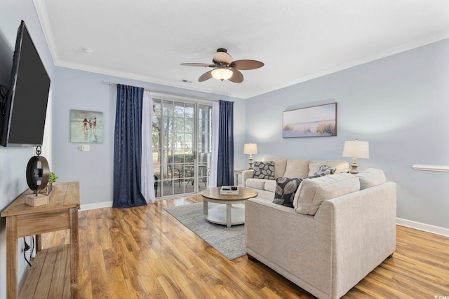 living room with light wood finished floors, ceiling fan, baseboards, and ornamental molding