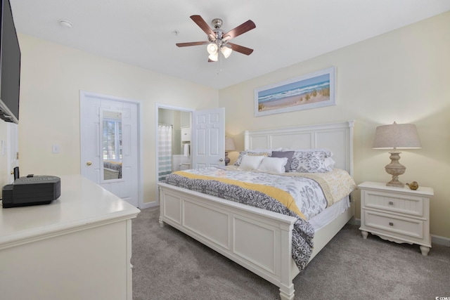 bedroom featuring light carpet, baseboards, ensuite bathroom, and ceiling fan