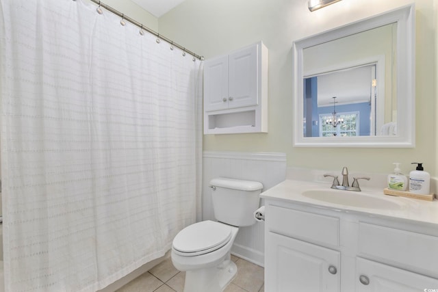 full bath with vanity, a shower with shower curtain, toilet, tile patterned floors, and a notable chandelier