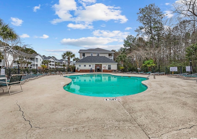 community pool with a patio and fence