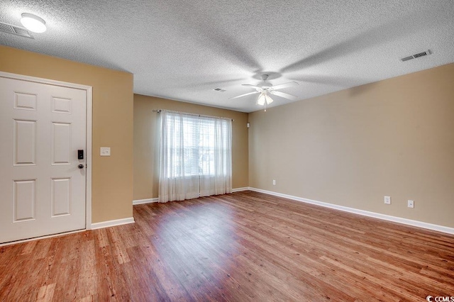 entrance foyer with visible vents, ceiling fan, and wood finished floors