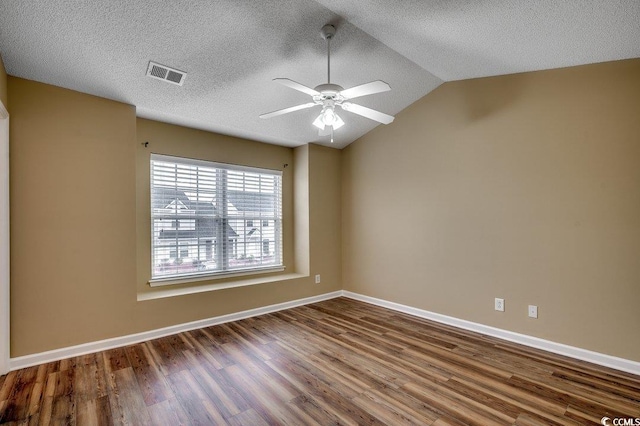 spare room with a ceiling fan, visible vents, baseboards, lofted ceiling, and dark wood-style flooring