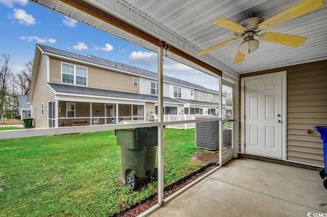 unfurnished sunroom featuring a residential view and a ceiling fan