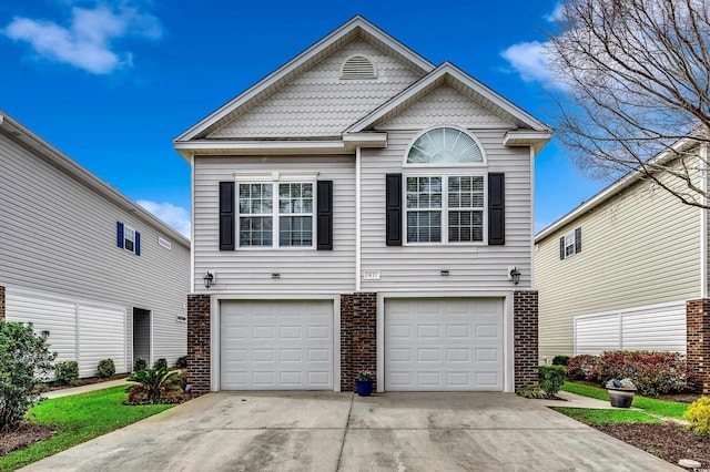 traditional-style house featuring a garage, brick siding, and concrete driveway