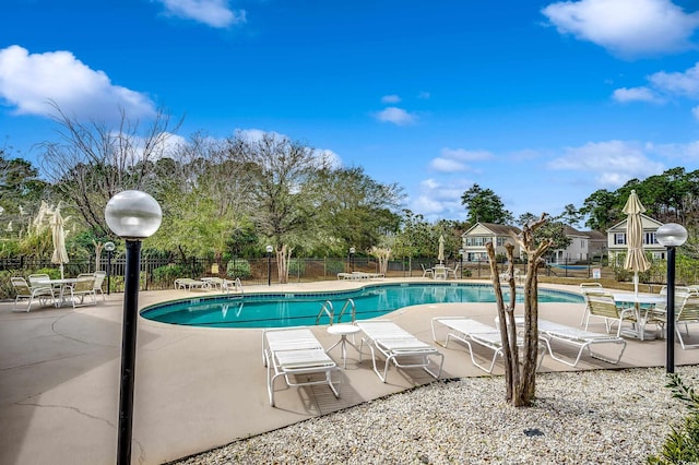 community pool featuring a patio and fence