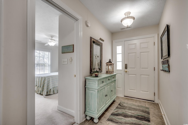 entrance foyer featuring baseboards, visible vents, and a textured ceiling