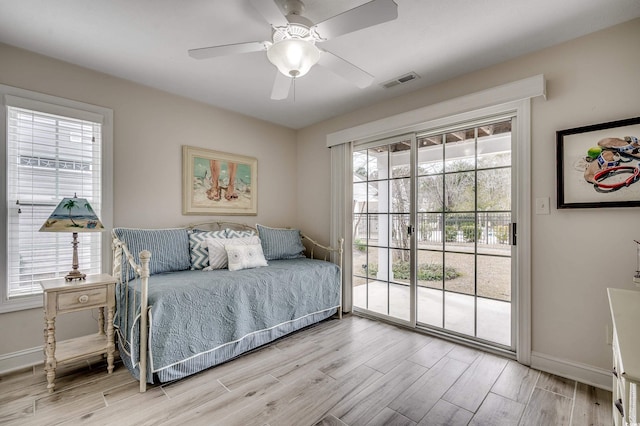 bedroom with visible vents, baseboards, light wood-style floors, and access to outside