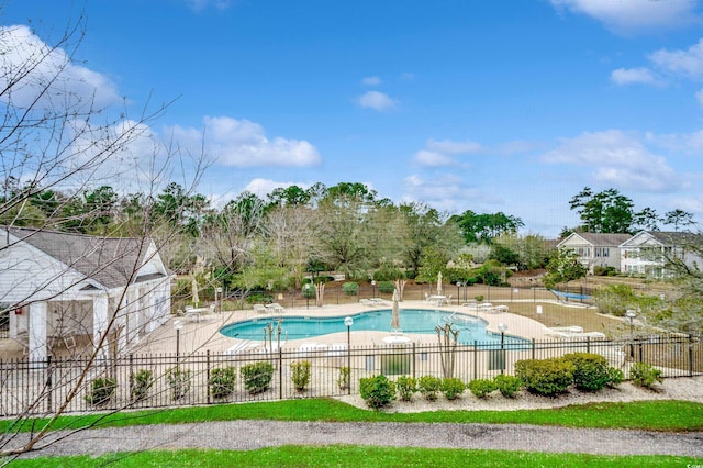 pool with a patio area and fence