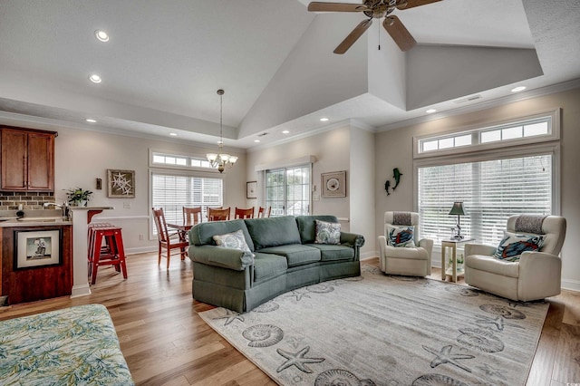 living room with baseboards, visible vents, light wood finished floors, high vaulted ceiling, and crown molding