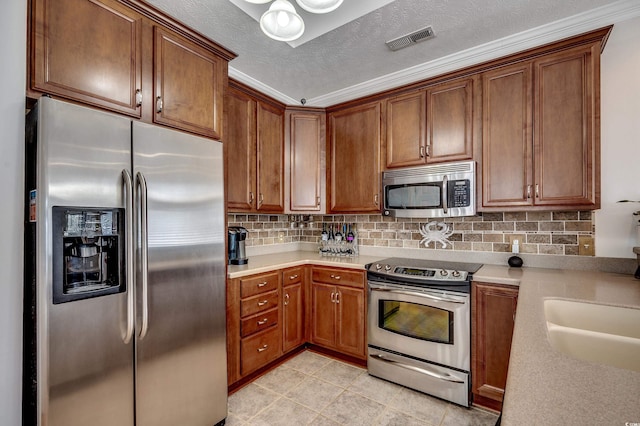 kitchen featuring tasteful backsplash, visible vents, stainless steel appliances, and light countertops