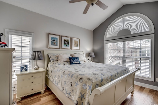 bedroom with multiple windows, light wood-style floors, and lofted ceiling