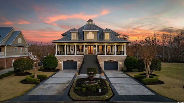 view of front facade featuring a standing seam roof, covered porch, metal roof, brick siding, and stairs