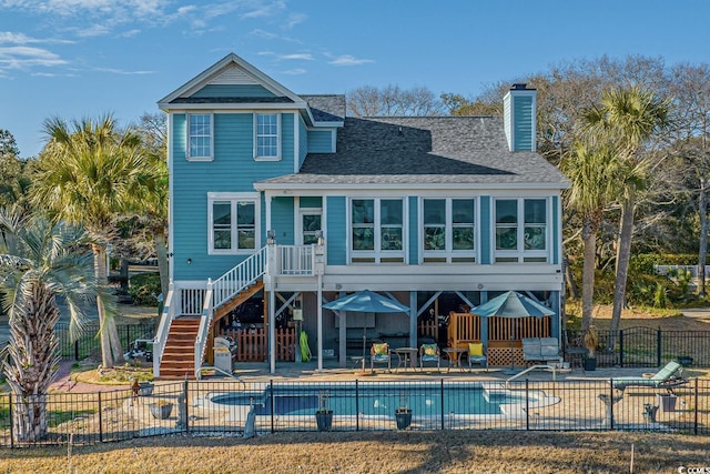 back of house with a patio, fence, a fenced in pool, roof with shingles, and stairs