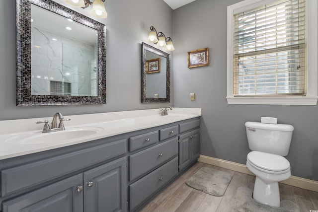 full bath featuring wood finished floors, toilet, baseboards, and a sink